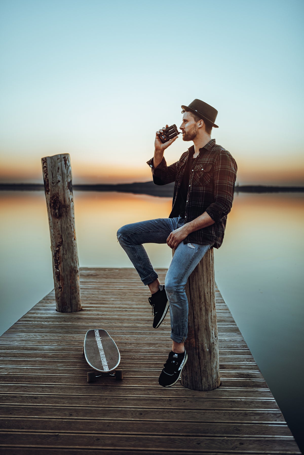 Mann mit Mighty+ Vaporizer auf einem Steg am See